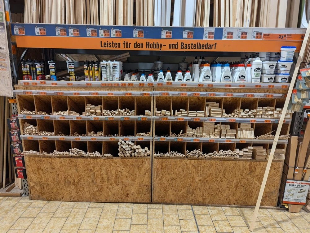 Hobby- und Bastelbedarf eines Baumarktes. Zu sehen sind Leim Runde und eckige Holz-Leisten