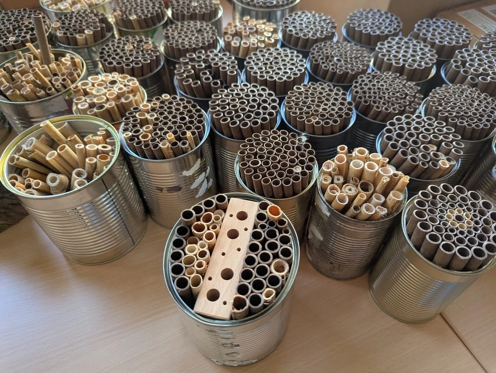 Sehr viele fertige Insektenhotels. Die Insektenhotels bestehen aus Bambusrohre oder Holzrohre in 400g Konservendosen