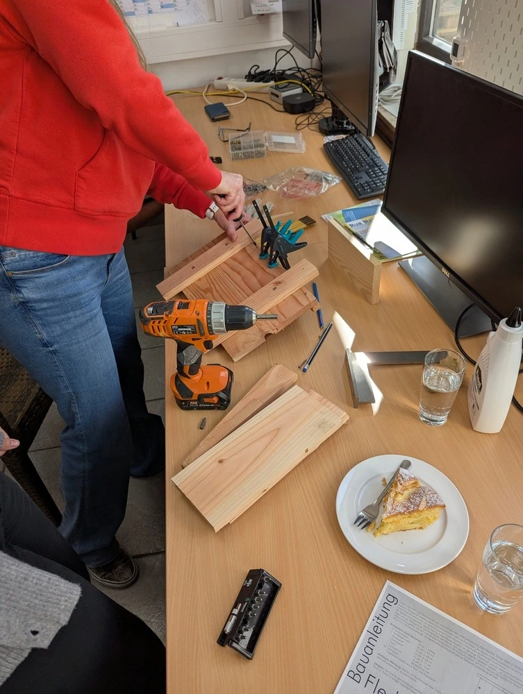 Eine Person schraubt einen Fledermauskasten zusammen