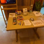 Der Empfangstisch befüllt mit Snacks, Wasser Werbung und Haftungsbegrenzungen