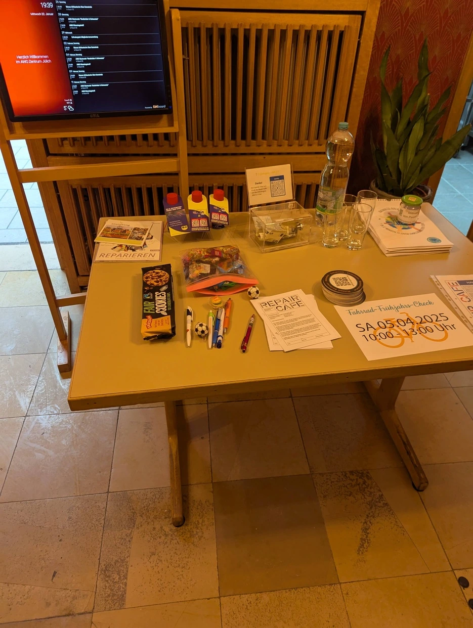 Der Empfangstisch befüllt mit Snacks, Wasser Werbung und Haftungsbegrenzungen