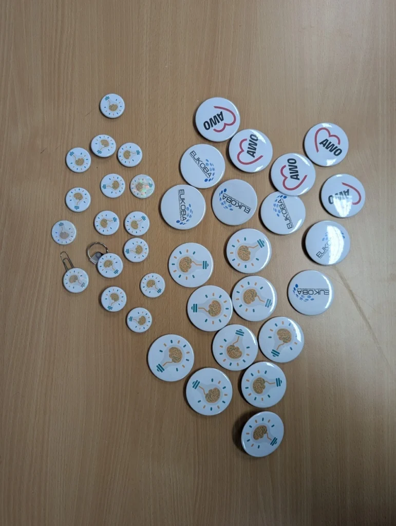Vielzahl an möglichen Buttons, die hergestellt werden können. Mit den Logos der AWO, Eukoba und Erfindergeist